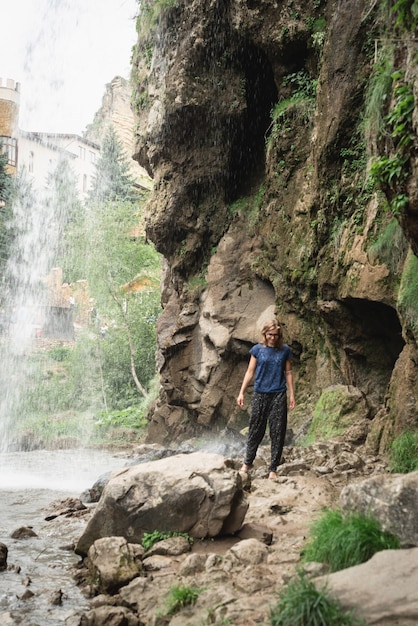 Natureza bela. Viajar por. Mulher caminhando pela bela cachoeira da montanha