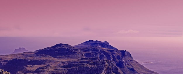 Foto natureza do topo da montanha e fundo de céu rosa para viagens de caminhada e turismo ecológico com a bandeira da cidade do cabo vista aérea da paisagem do pôr-do-sol e do mar ou oceano no horizonte na áfrica do sul