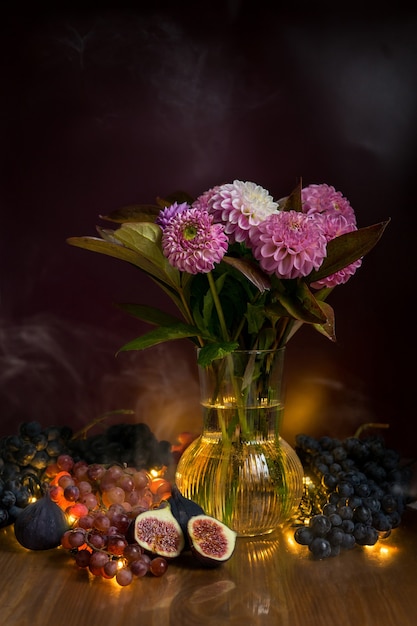 Natureza morta com bouquet de floração de dálias e uvas e figos. foto de alta qualidade