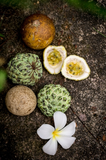 Natureza morta com frutas exóticas úteis sobre fundo de pedra