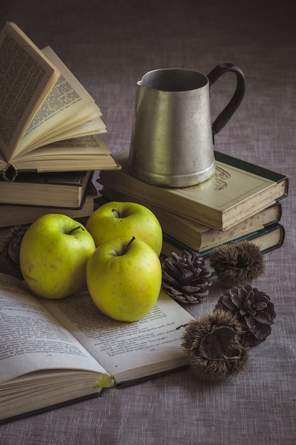 Foto natureza morta com maçãs e livros