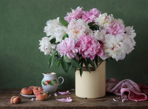 Natureza morta com um buquê de peônias rosa e brancas em latas.