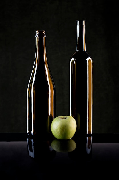 Foto natureza morta com uma maçã e garrafas de vidro