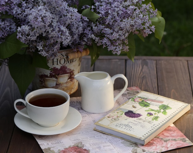 natureza morta com uma xícara de chá matinal e flores lilás