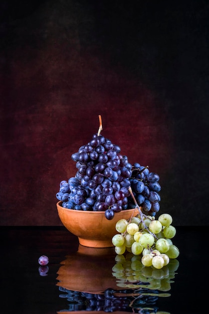 Natureza morta com uvas em um fundo escuro