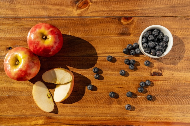 Natureza morta de ação de Graças com frutas de outono, nozes e bagas na mesa de madeira. Comida saudável,