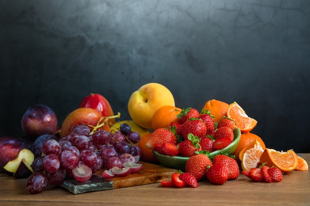 Natureza morta de frutas frescas da estação de tons avermelhados