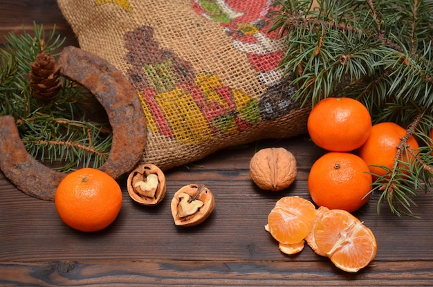 Natureza morta de inverno com tangerinas, um saco de presentes e uma ferradura