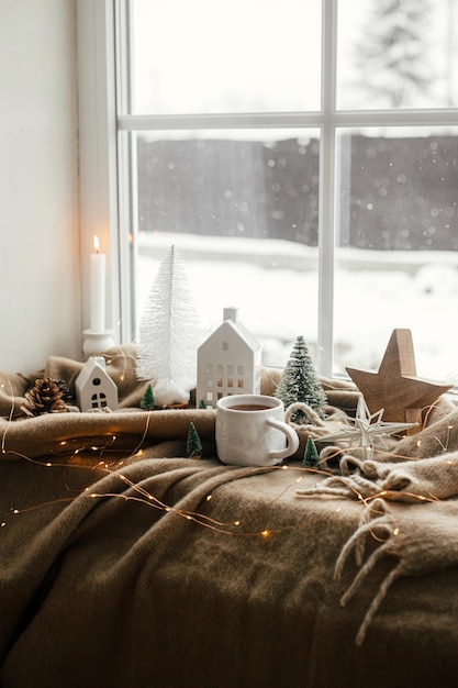 Natureza morta de Natal higiênico de inverno em casa Xícara quente de chá decoração de natal e luzes na janela