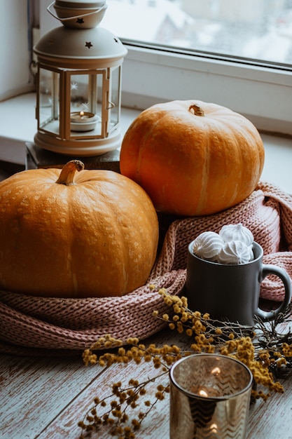 Natureza morta de outono celebrando o Halloween ou o Dia de Ação de Graças, lanterna de abóboras laranja maduras com velas