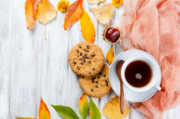 Natureza morta de outono com xícara de chá, biscoitos e folhas