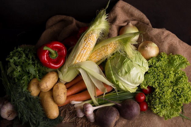 Natureza-morta escura e mal-humorada de legumes frescos em uma mesa de madeira Comida local orgânica saudável