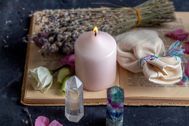 Foto natureza morta mágica com fluorita, cristal de quartzo e vela rosa.