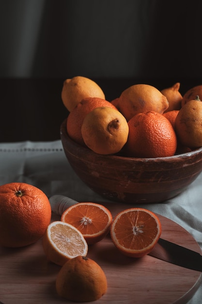 Natureza morta sobre um fundo escuro Close-up de laranjas e limões na mesa de madeira