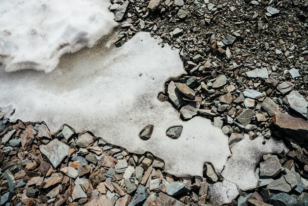 Naturhintergrund des Schnees auf chaotischem Steinhaufen.