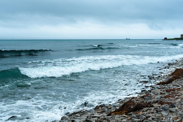 Naturhintergrund mit Meereswellen, die das Meer treffen Malerischer Blick auf das Meer gegen bewölkten Himmel