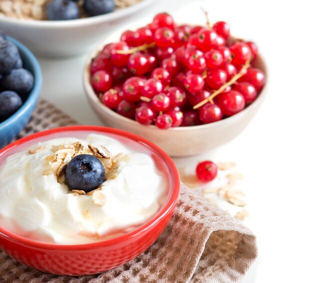 Naturjoghurt, frische Beeren und Müsli auf einer Serviette. Gesundes Frühstückskonzept