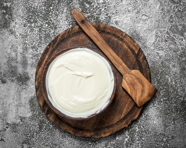 Naturjoghurt in einer Schüssel. Auf einem rustikalen Hintergrund.