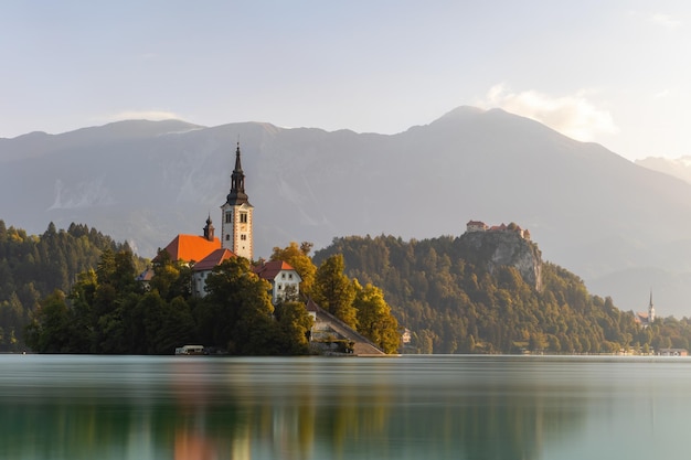 Naturlandschaft aus den Julien-Alpen mit Gipfel im Hintergrund und Kirche in der Nähe von Wasser