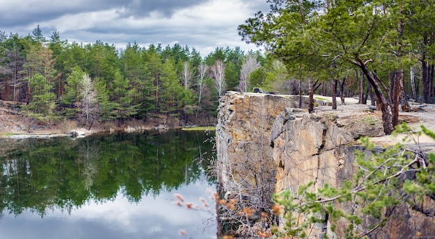 Naturlandschaft, schöner See im Wald, blauer Himmel und hohe Felsen