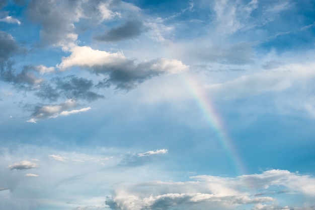 Naturphänomen des Regenbogenbogens mit Wolken im Himmel