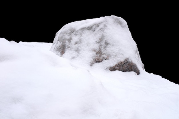 Naturstein im Schnee auf schwarzem Hintergrund isoliert. Foto in hoher Qualität