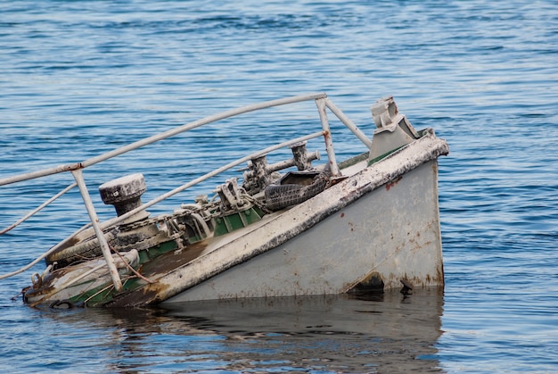 Foto naufrágio de um navio enferrujado em um rio azul