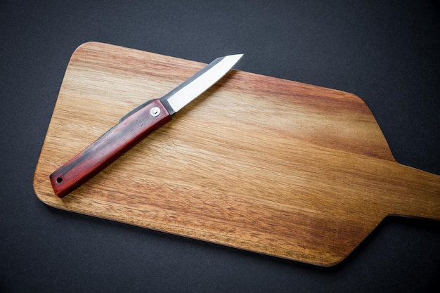 Navaja de bolsillo japonesa tradicional en una tabla de cortar de madera