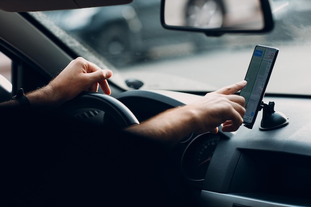 Navegador no carro veículo transporte viajante homem motorista usando o aplicativo de navegação do telefone móvel enquanto dirige o carro