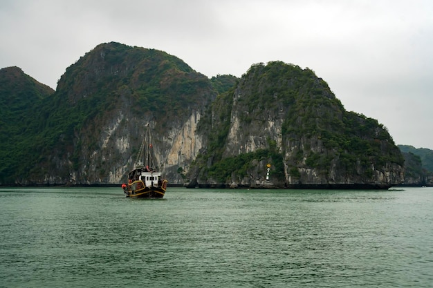 Navegando entre hermosas rocas de piedra caliza y playas solitarias en la bahía de Ha Long, sitio del patrimonio mundial de la UNESCO en Vietnam