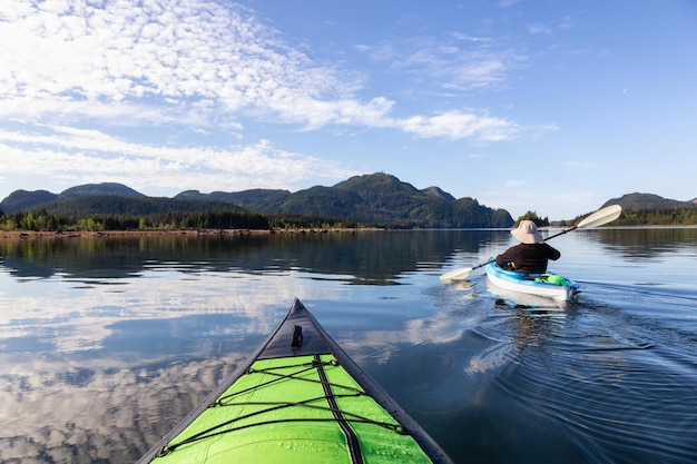 Navegar en kayak durante una mañana vibrante rodeada por el paisaje montañoso canadiense