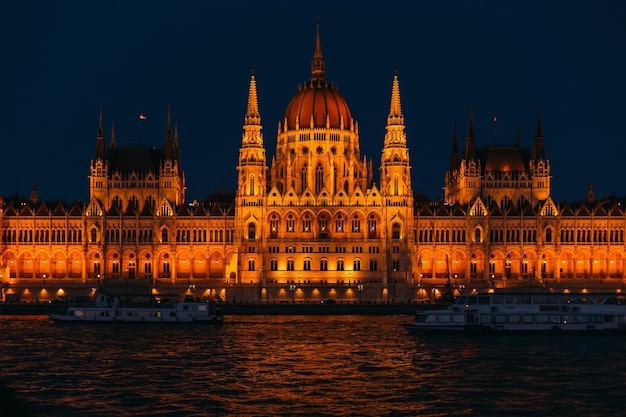 Naves en el río frente al parlamento en la noche Budapest