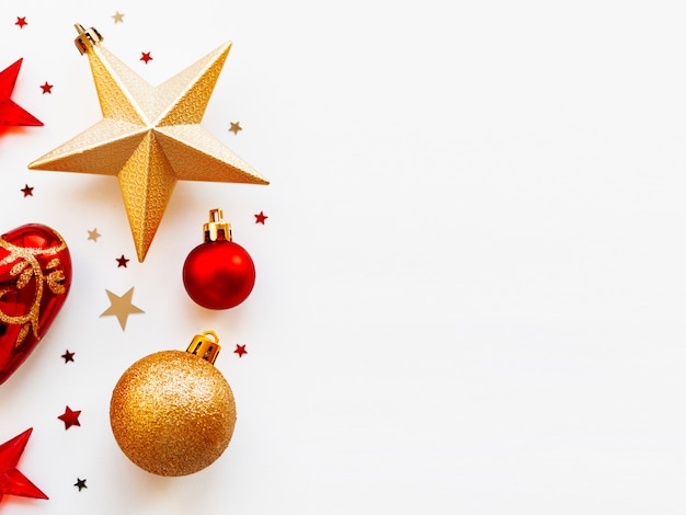 Navidad y 2020 con decoraciones, en forma de círculo. Bolas doradas y rojas, estrellas, confeti y corazón.