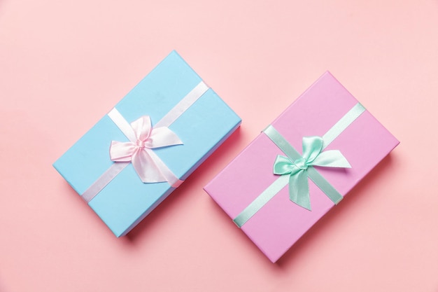 Navidad, año nuevo, cumpleaños, san valentín, celebración, presente, romántico, concepto. Pequeña caja de regalo envuelta en papel rosa y azul aislado sobre fondo rosa pastel colorido de moda. Espacio de copia de vista superior plana endecha