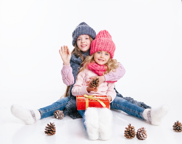 Navidad. Año nuevo. Dos pequeñas hermanas que se sostienen presentes en la ropa del invierno.