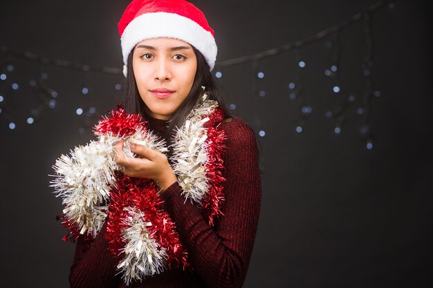 Navidad y año nuevo vacaciones retrato aislado en fondo negro joven latina en rojo