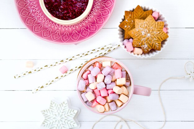 Navidad cacao malvavisco rosa taza y jengibre galletas blanco mesa de madera mermelada de frambuesa