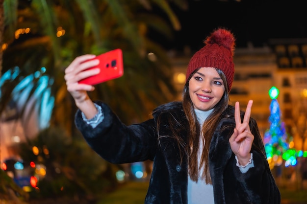 Navidad en la ciudad decoración de invierno Disfrutando de la noche haciéndote un selfie sonriendo