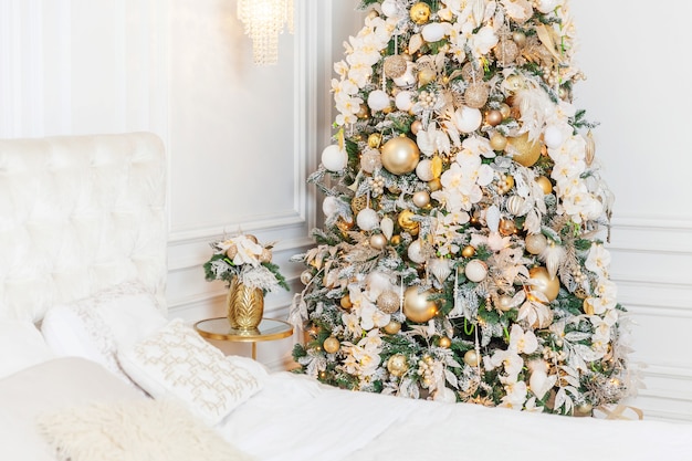 Navidad clásica Año nuevo decorado interior habitación Árbol de año nuevo. Árbol de Navidad con adornos dorados. Apartamento de diseño de interiores de estilo clásico blanco moderno. Nochebuena en casa.