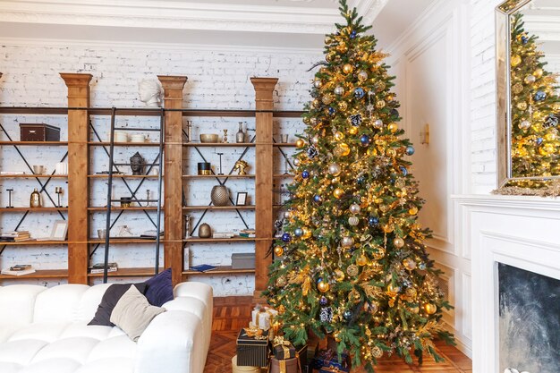 Navidad clásica Año nuevo decorado interior habitación Árbol de año nuevo. Árbol de Navidad con adornos dorados. Apartamento de diseño de interiores de estilo clásico blanco moderno. Nochebuena en casa.