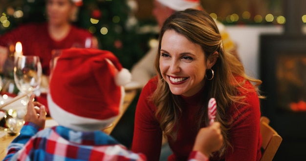 La Navidad es un momento para apreciar las pequeñas cosas Foto de una mujer joven disfrutando de una cena de Navidad con su hijo y su familia en casa