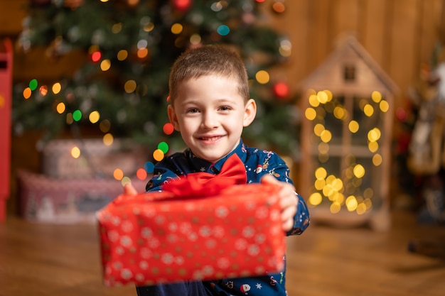 Navidad fabulosa, niño sosteniendo una gran caja roja con un regalo de Santa.
