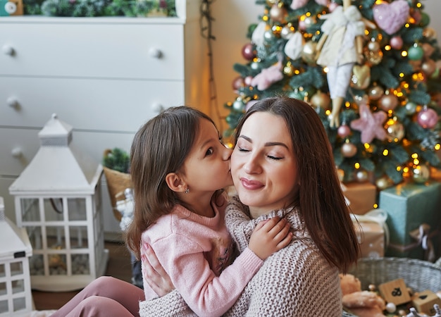 Navidad, familia, mujer, madre e hija, niño, en, plano de fondo, de, árbol de navidad