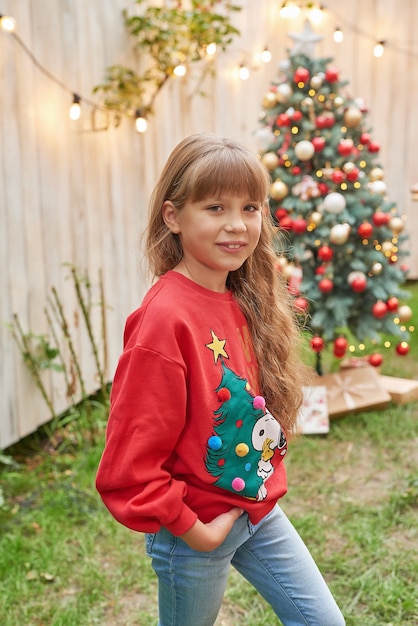 Navidad familiar en julio Retrato de niña cerca del árbol de Navidad con regalos