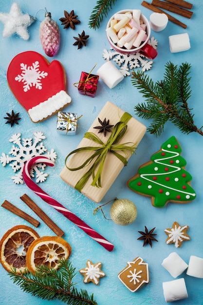 Navidad. Grupo de pan de jengibre, canela, naranja, juguetes y taza de chocolate caliente en azul claro.