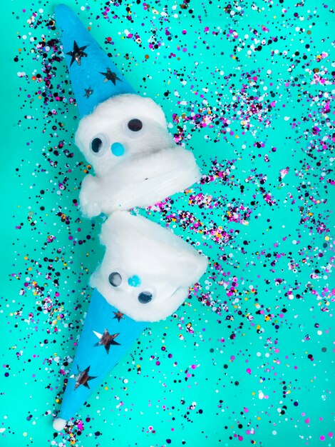 Navidad hermosos muñecos de nieve caseros sobre fondo de color de moda neo menta festivo con confeti