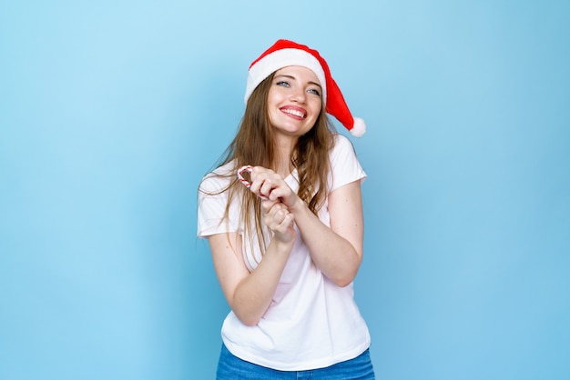 Navidad mujer belleza modelo niña con sombrero de santa claus con labios rojos y piruleta de Navidad en la mano alegría sur ...