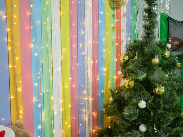 Navidad multicolor con bombillas y fondo de rayas de árbol de Navidad. Foto de alta calidad