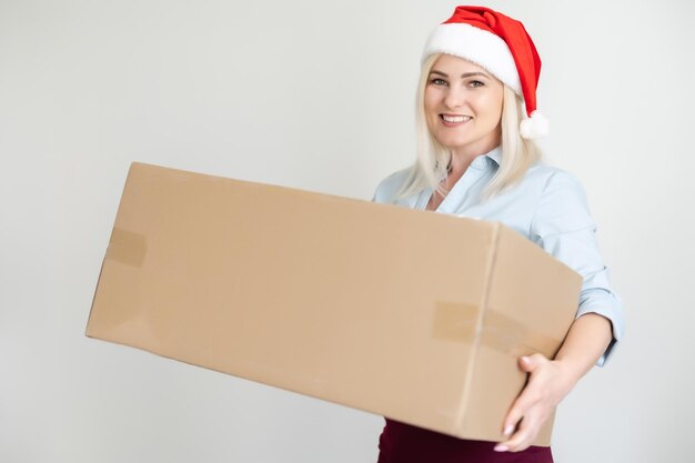 Navidad, Navidad, invierno, concepto de felicidad - mujer sonriente con sombrero de ayudante de santa con caja de paquetería