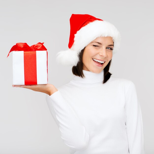 Navidad, Navidad, invierno, concepto de felicidad - mujer sonriente con sombrero de ayudante de santa con caja de regalo